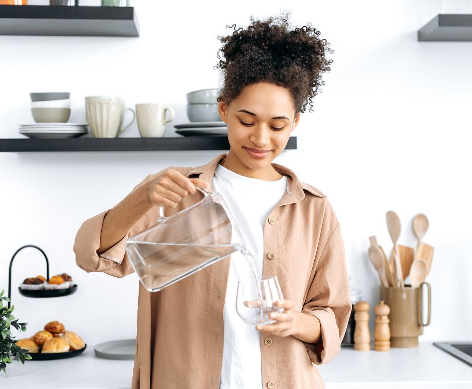 A Person With Clear Skin Pouring A Glass Of Water