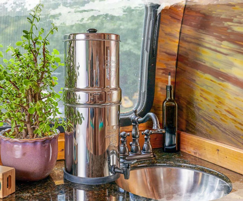 A Big Berkey water filter next to a sink ready to filter tap water.