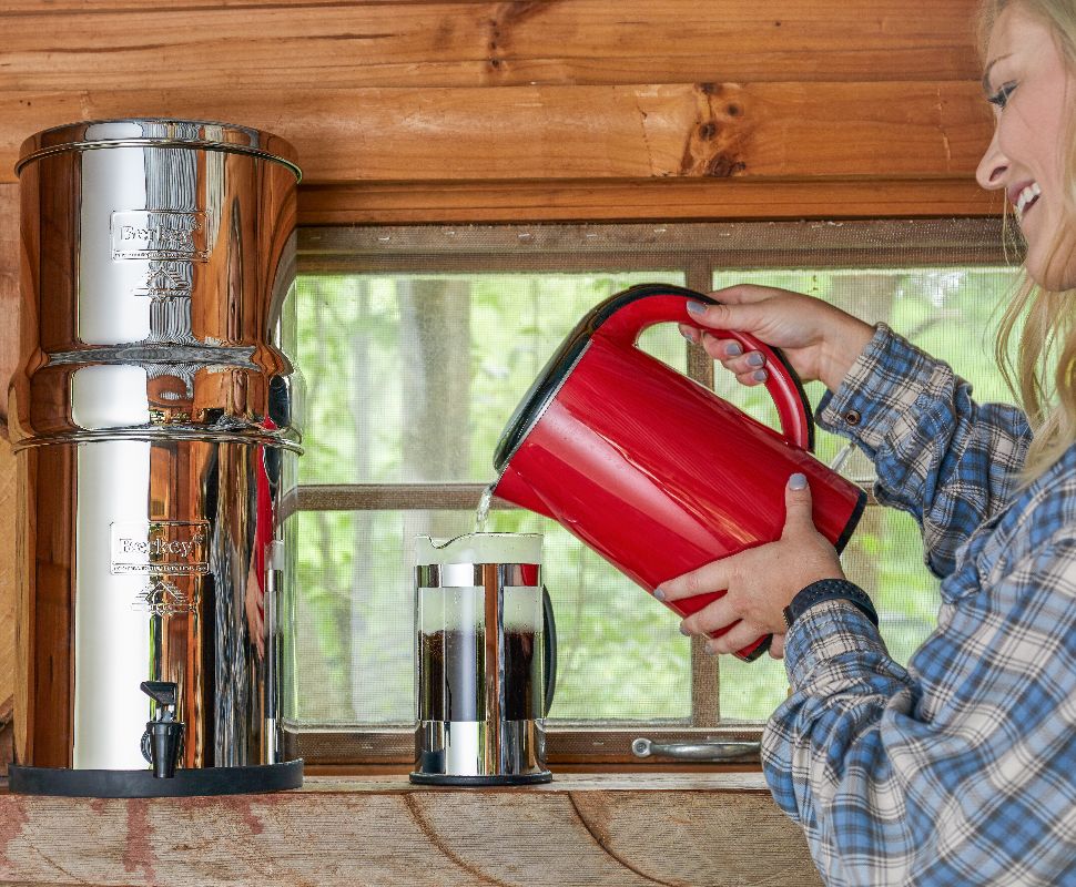 Someone making coffee in a french press using water from their Berkey water system
