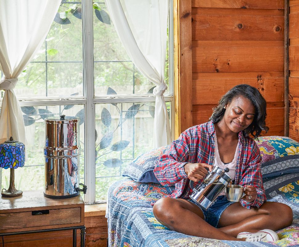 Someone making coffee in a french press with water from their Berkey Water Filter