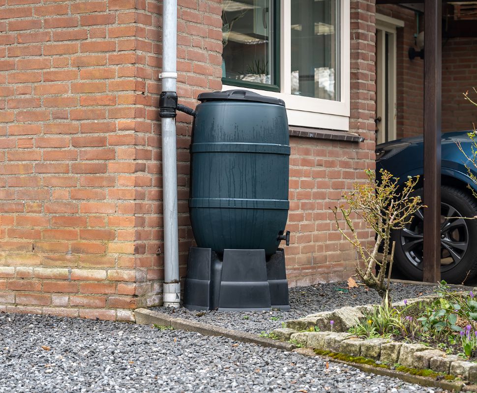 Rainwater Collection + Berkey = Self-Reliant Water System A rain water collector bucket on the side of a house.