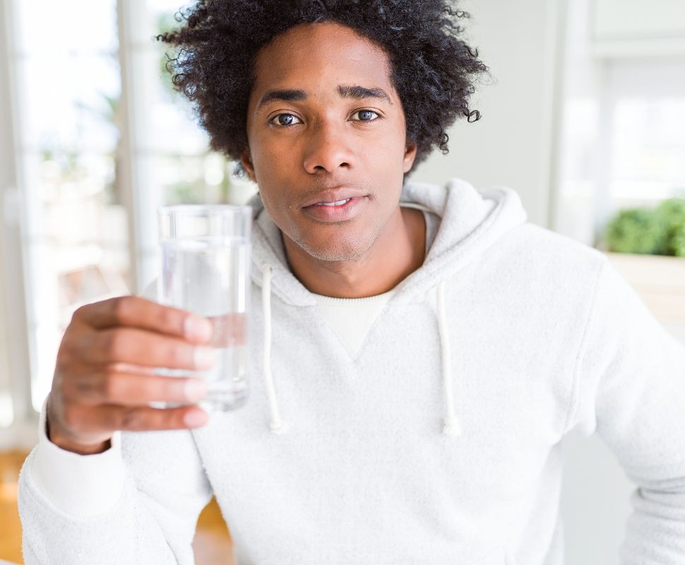 How Clean Is Clean Enough? The Psychology Behind Water Anxiety Someone holding a glass of water looking concerned.