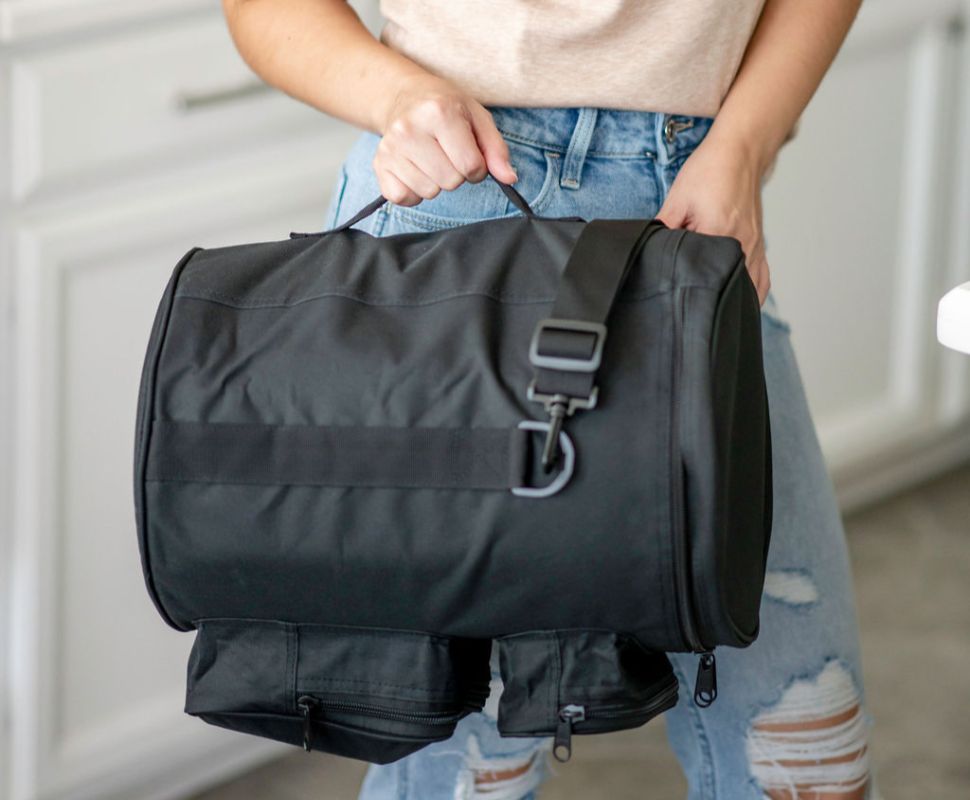 Someone holding a travel bag with a berkey water filter inside.