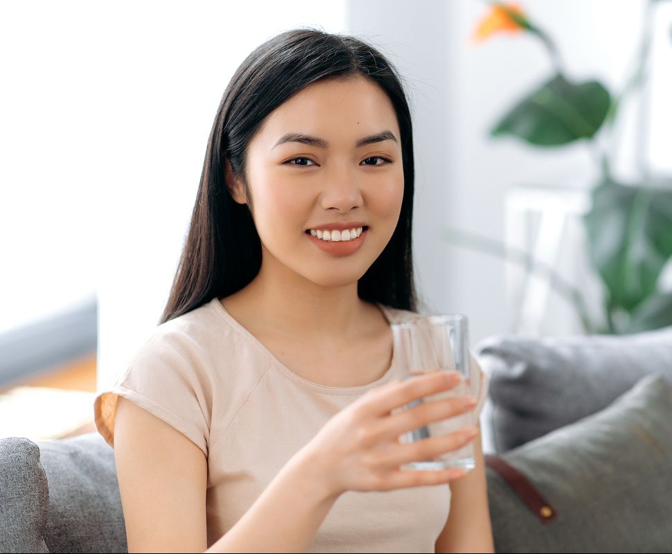 A person with a glass of water, smiling.